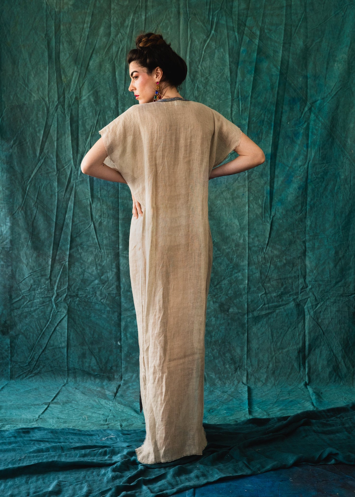 Beige caftan-style dress with intricate embellishments