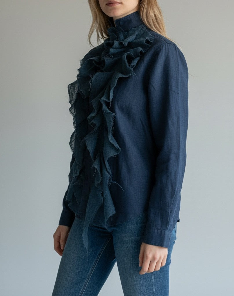 Person wearing a dark blue blouse with ruffled details 